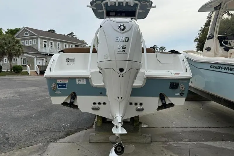 Slide: The Image of 2023 Sea Hunt Ultra 255 SE boat with Yamaha 300 V6 engine, docked outdoors. - 2