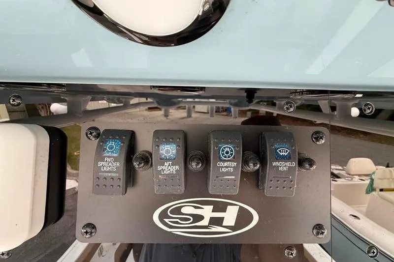 Slide: The Image of Control panel of 2023 Sea Hunt Ultra 255 SE boat with light switches. - 26