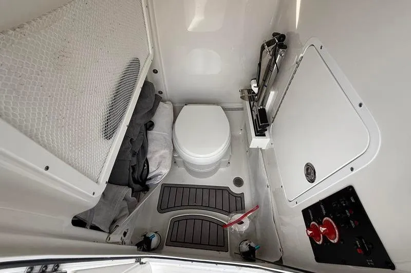 Slide: The Image of 2023 Sea Hunt Ultra 255 SE boat interior with compact marine toilet and storage. - 30