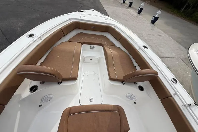 Slide: The Image of 2023 Sea Hunt Ultra 255 SE boat interior with brown cushioned seating. - 31