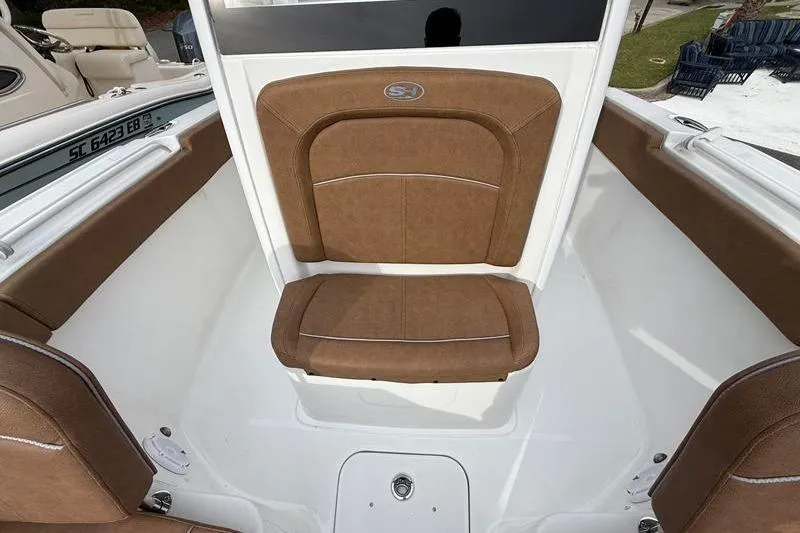 Slide: The Image of 2023 Sea Hunt Ultra 255 SE boat interior with brown cushioned seating. - 32