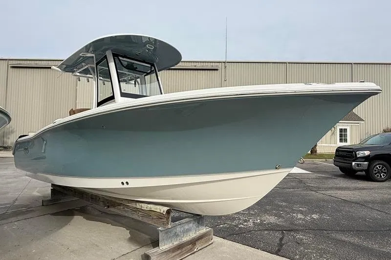 Slide: The Image of 2023 Sea Hunt Ultra 255 SE boat displayed outdoors on a stand. - 4