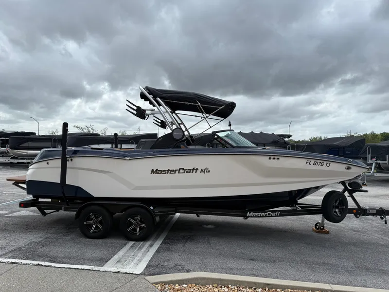 Slide: The Image of 2022 MasterCraft NXT24 boat on trailer under cloudy sky. - 5