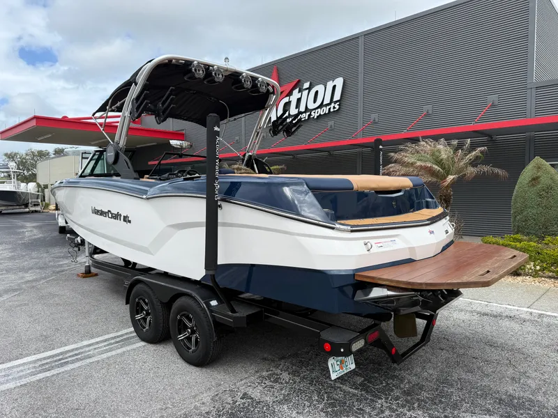Slide: The Image of 2022 MasterCraft NXT24 boat on trailer outside a store. - 8