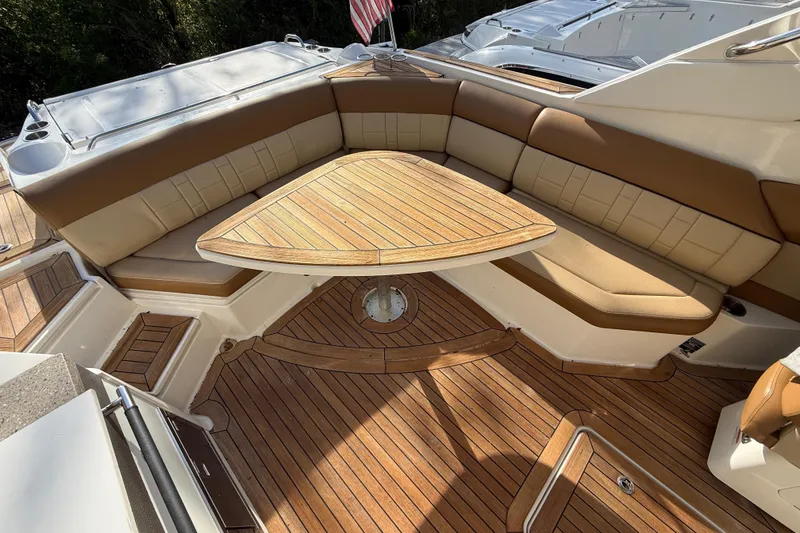 Slide: The Image of Luxurious seating area on a 2014 Sea Ray SLX 350 boat with wooden table and cushions. - 40