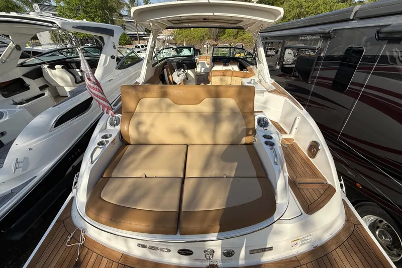 Slide: The Image of 2014 Sea Ray SLX 350 boat with luxurious seating and wooden deck, docked alongside other boats. - 6