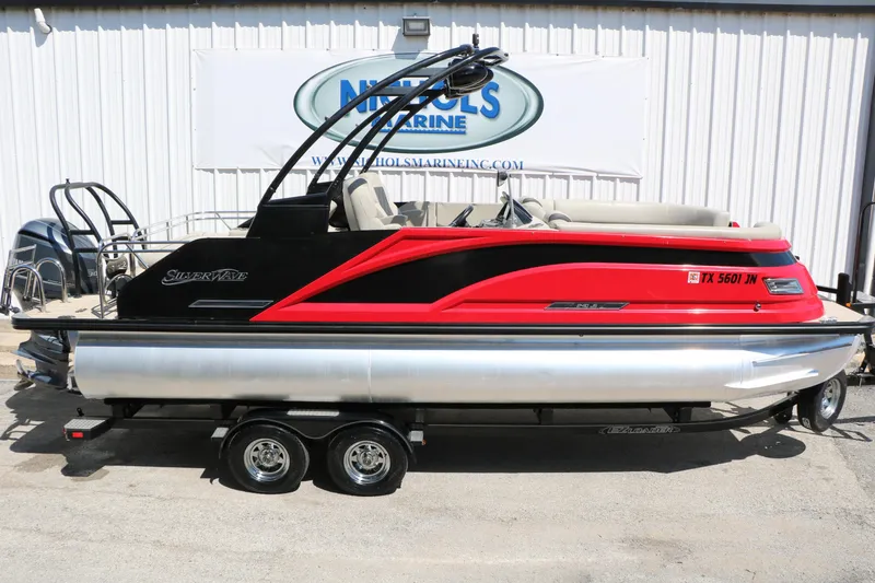 Slide: The Image of 2021 Silver Wave 2410 SW5 JS pontoon boat in vibrant red and black, on a trailer. - 14