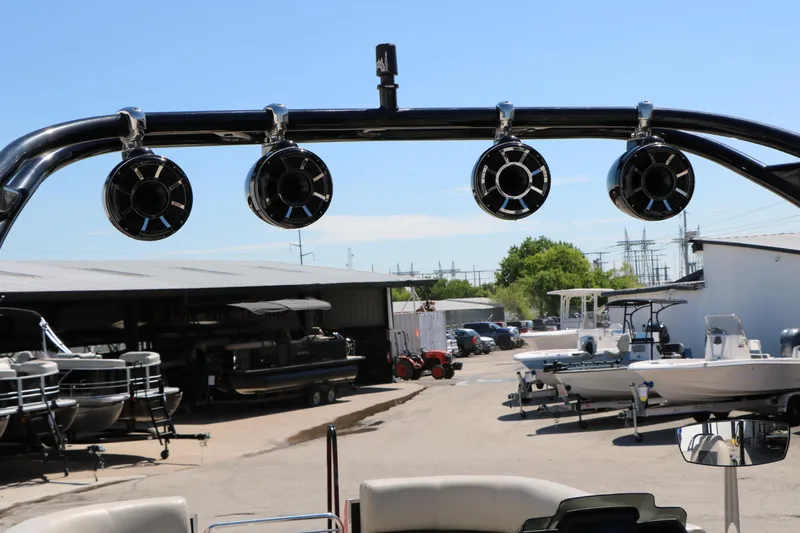 Slide: The Image of 2021 Silver Wave 2410 SW5 JS boat with mounted speakers in a marina setting. - 26