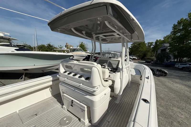 Slide: The Image of 2020 Intrepid 327 Center Console boat with modern helm and seating, docked outdoors. - 14