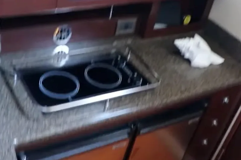 Slide: The Image of Kitchen area of 2007 Sea Ray 36 Sedan Bridge with stove and countertop. - 17