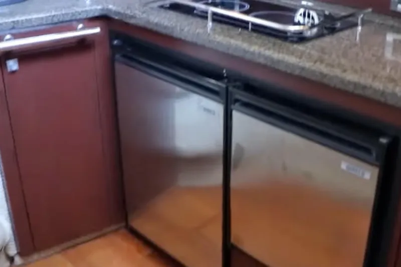 Slide: The Image of Kitchen area of 2007 Sea Ray 36 Sedan Bridge with stainless steel appliances. - 19