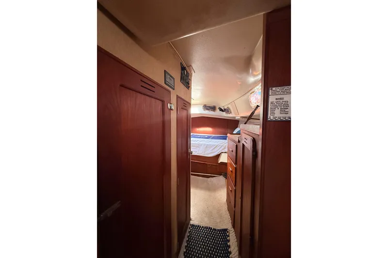 Slide: The Image of Interior of a 1978 Morgan 452 sailboat cabin with wooden furnishings and cozy bedding. - 15