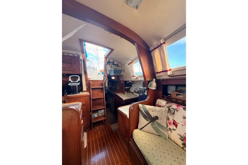 Slide: The Image of Interior of a 1978 Morgan 452 sailboat with wooden finishes and cozy seating. - 19