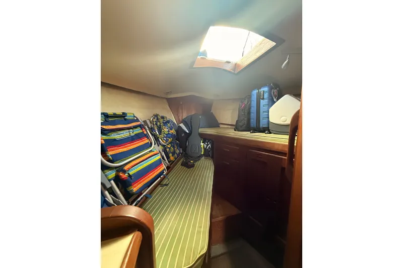 Slide: The Image of Interior cabin of a 1978 Morgan 452 sailboat with luggage and striped chairs. - 21