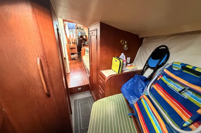 Slide: The Image of Interior of a 1978 Morgan 452 sailboat with wooden cabinetry and colorful seating. - 22