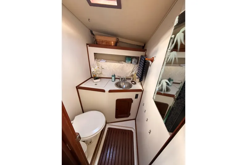 Slide: The Image of 1978 Morgan 452 yacht bathroom with sink, toilet, and mirror, featuring wooden accents. - 23