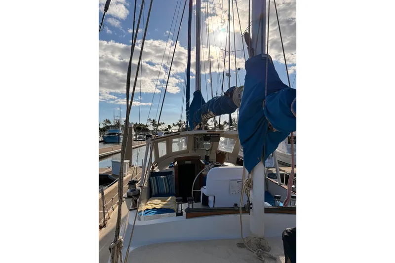 Slide: The Image of 1978 Morgan 452 sailboat deck with blue sails in a sunny marina. - 29