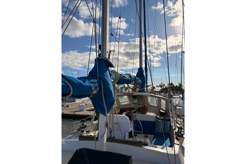 Slide: The Image of 1978 Morgan 452 sailboat docked, featuring blue sail covers and clear sky. - 31
