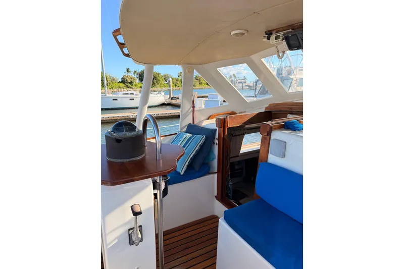 Slide: The Image of 1978 Morgan 452 yacht interior with blue seating and wooden accents, docked at marina. - 35