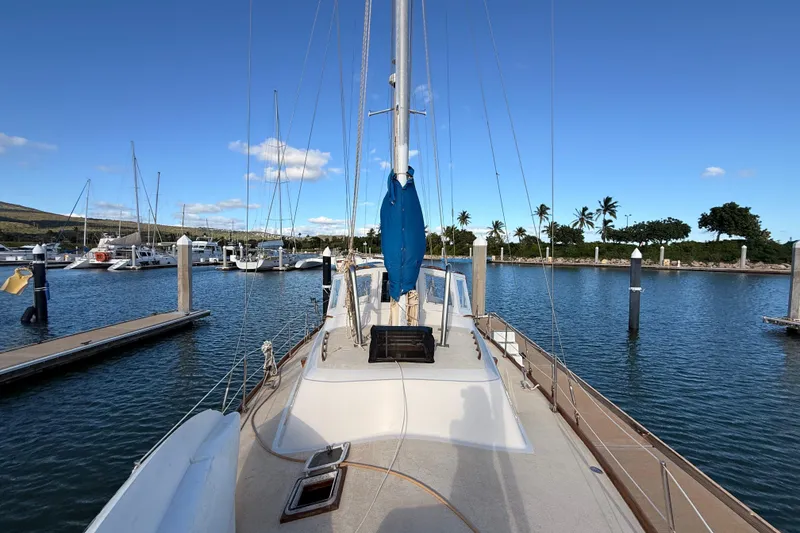 Slide: The Image of 1978 Morgan 452 sailboat docked in a serene marina with clear blue skies. - 40