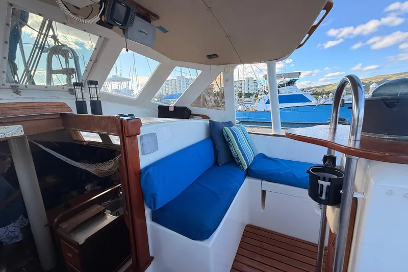 Slide: The Image of 1978 Morgan 452 yacht interior with blue seating, docked at marina under clear sky. - 45