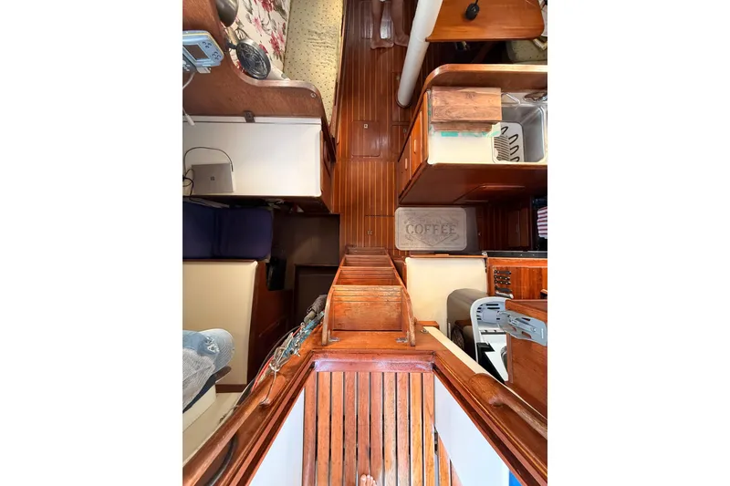Slide: The Image of Interior view of a 1978 Morgan 452 sailboat, featuring wooden flooring and compact living space. - 47