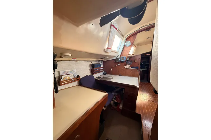 Slide: The Image of Interior of a 1978 Morgan 452 sailboat featuring a cozy navigation station and wooden accents. - 51
