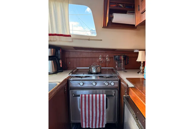 Slide: The Image of 1978 Morgan 452 yacht kitchen with stove, cookware, and wooden cabinetry. - 53