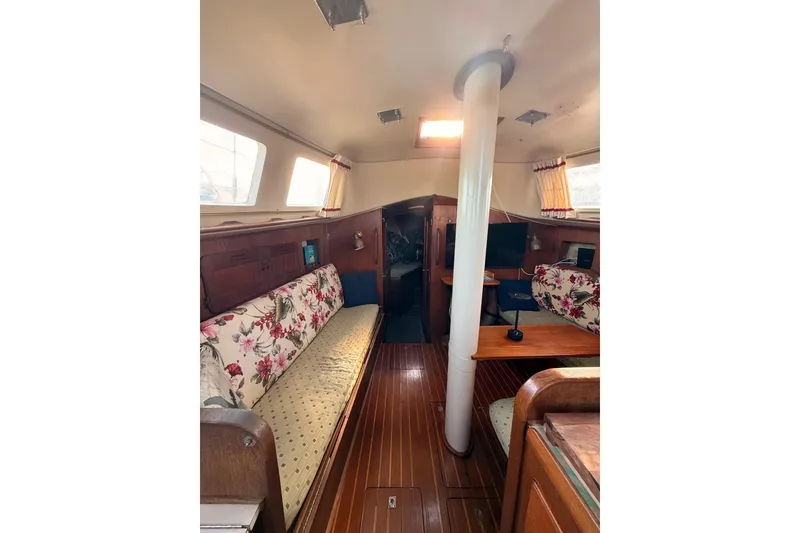 Slide: The Image of Interior of a 1978 Morgan 452 sailboat with floral upholstery and wooden flooring. - 57