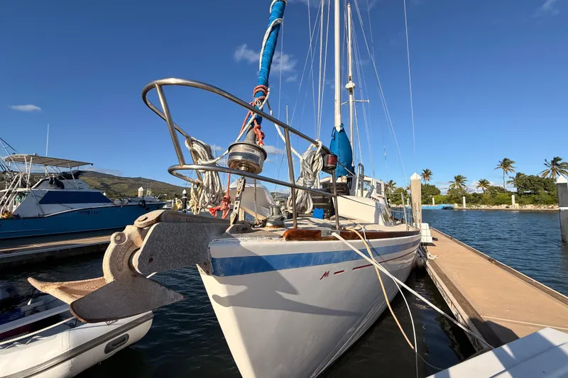 Slide: The Image of Sailboat Morgan 452 (1978) docked at marina with clear blue sky and palm trees. - 61