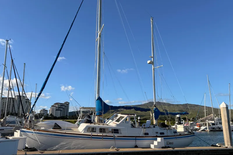 Slide: The Image of 1978 Morgan 452 sailboat docked in marina, clear blue sky, distant buildings and hills. - 65