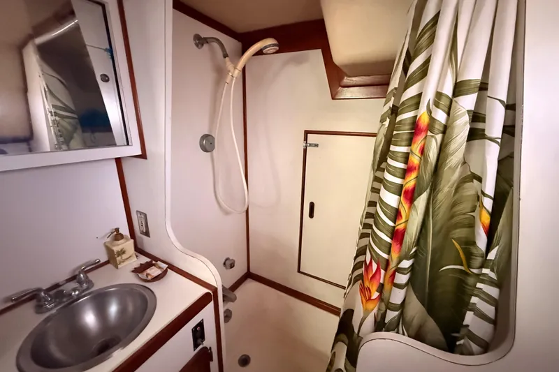 Slide: The Image of 1978 Morgan 452 yacht bathroom with tropical shower curtain and compact sink area. - 8