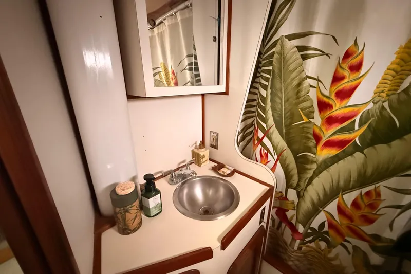 Slide: The Image of 1978 Morgan 452 yacht bathroom with tropical shower curtain and compact sink area. - 9
