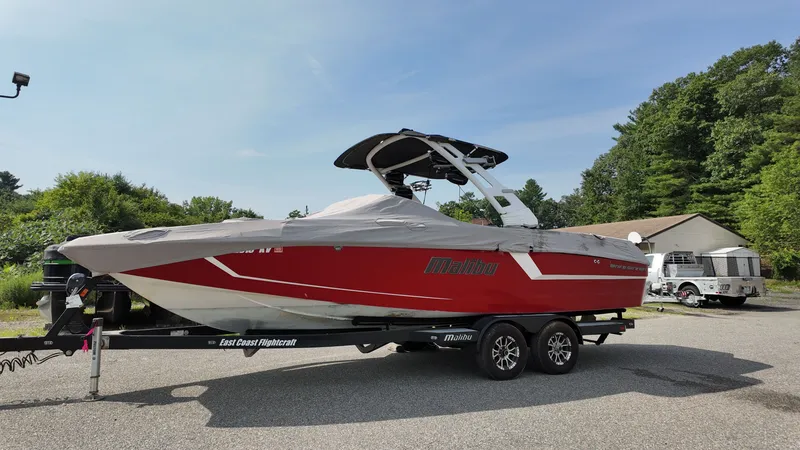 The Image of 2017 Malibu Wakesetter 24 MXZ boat on trailer, covered, parked outdoors. - 1