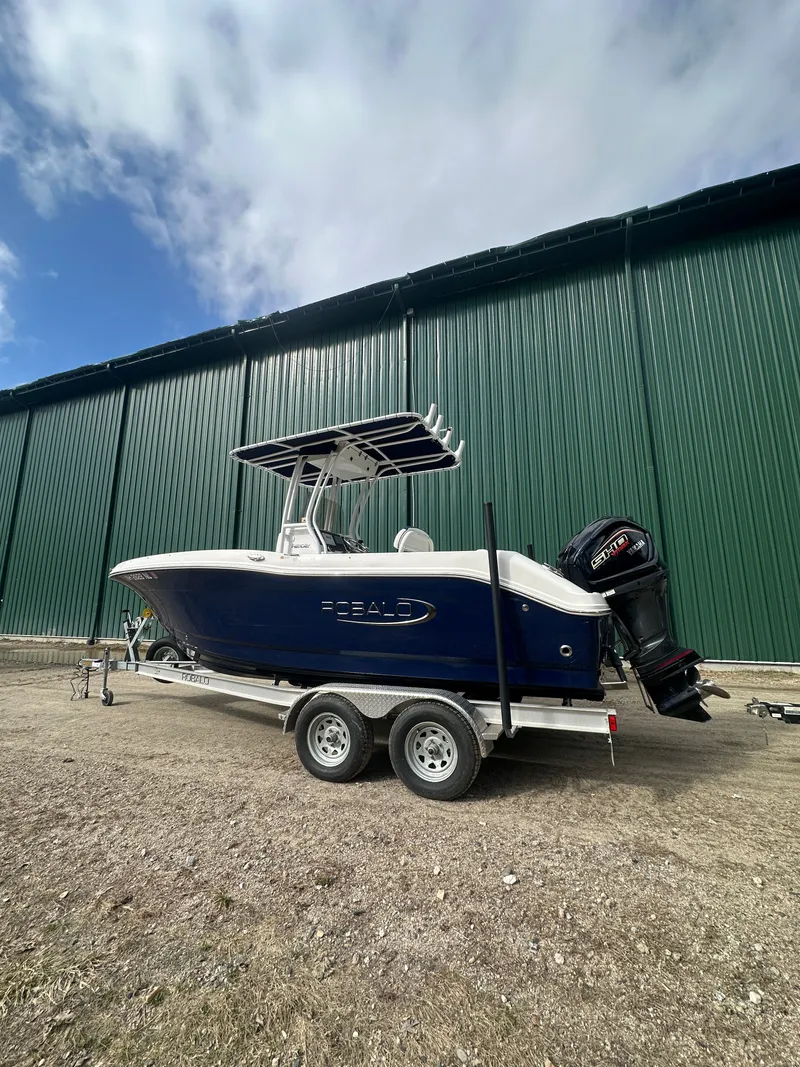 Slide: The Image of 2023 Robalo R202 Explorer boat on trailer in front of green building. - 3
