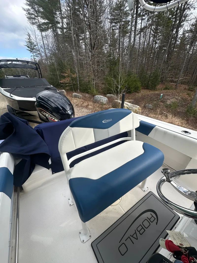 Slide: The Image of 2023 Robalo R202 Explorer boat with blue and white seating. - 9