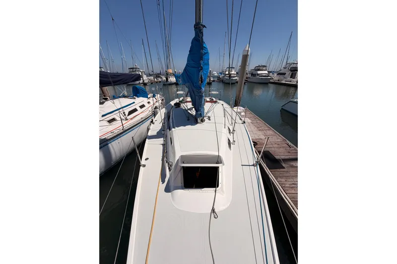 Slide: The Image of Sailboat Catalina 320, 1999 model, docked at marina with blue sail cover. - 12