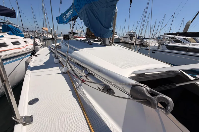 Slide: The Image of 1999 Catalina 320 sailboat docked in a marina, surrounded by other boats. - 13
