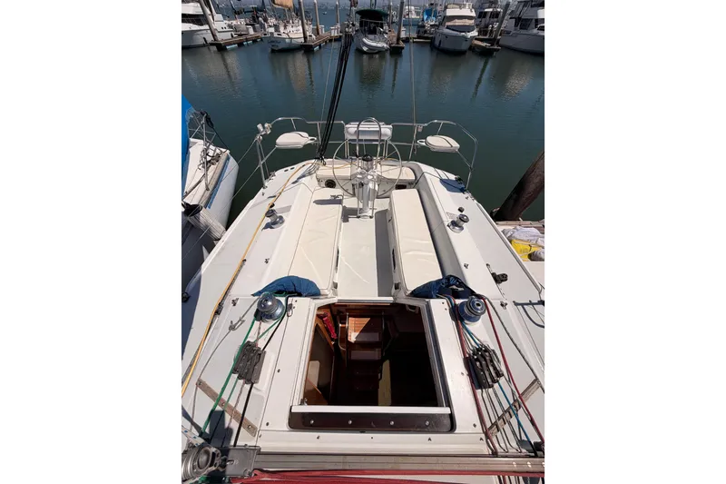 Slide: The Image of 1999 Catalina 320 sailboat docked in a marina, showcasing deck and cabin entrance. - 15