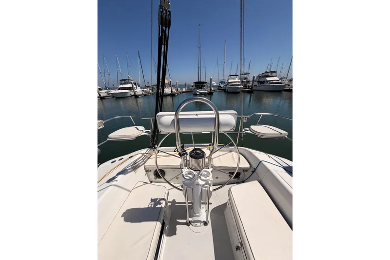 Slide: The Image of 1999 Catalina 320 sailboat cockpit view in marina with surrounding yachts. - 16