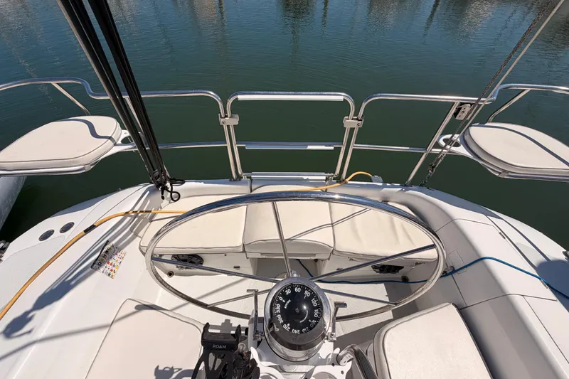 Slide: The Image of Cockpit view of a 1999 Catalina 320 sailboat with steering wheel and compass. - 17