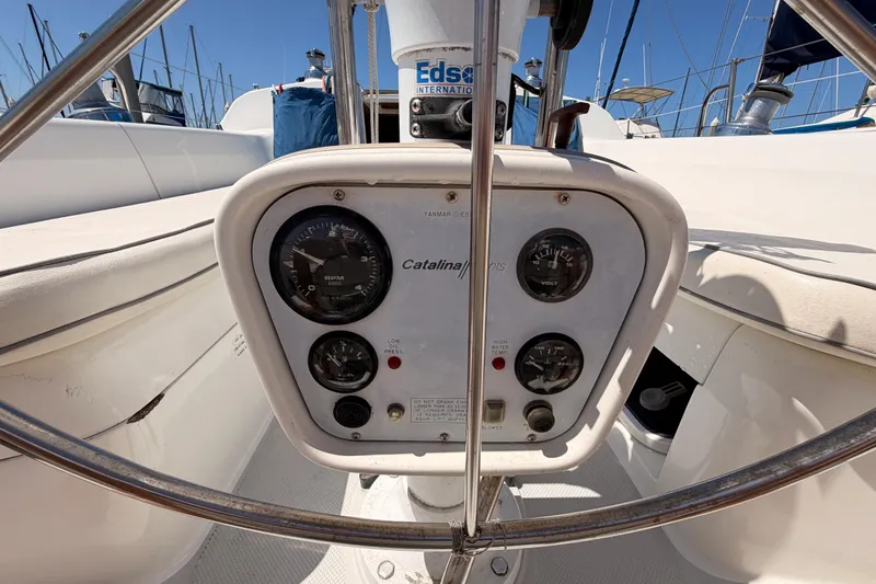 Slide: The Image of Cockpit controls of a 1999 Catalina 320 sailboat with gauges and steering wheel. - 18