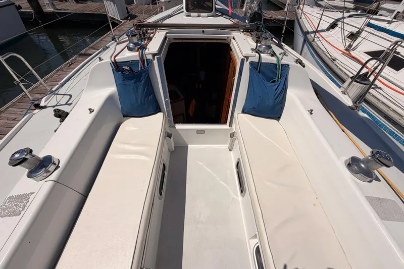 Slide: The Image of 1999 Catalina 320 sailboat cockpit with seating and winches at a marina. - 21