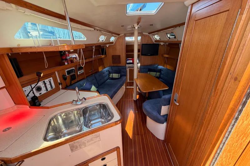 Slide: The Image of Interior of a 1999 Catalina 320 sailboat with cozy seating and wooden finishes. - 23