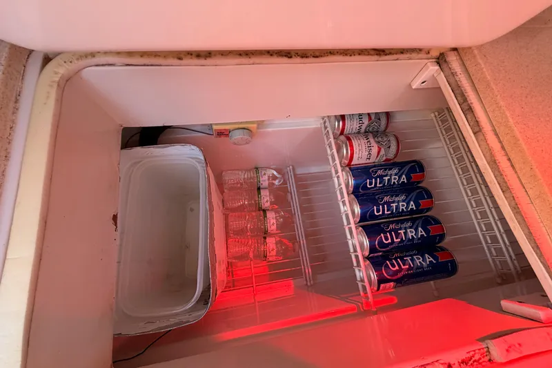 Slide: The Image of Mini fridge on a 1999 Catalina 320 yacht, stocked with beer cans and water bottles. - 26