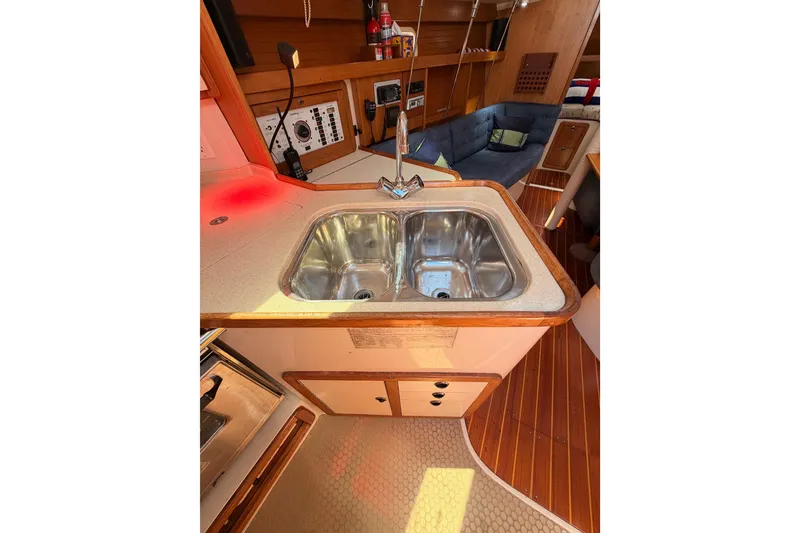 Slide: The Image of Interior of a 1999 Catalina 320 sailboat featuring a compact kitchen sink area. - 30