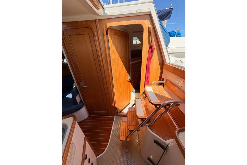 Slide: The Image of Interior view of a 1999 Catalina 320 sailboat with wooden doors and steps. - 31
