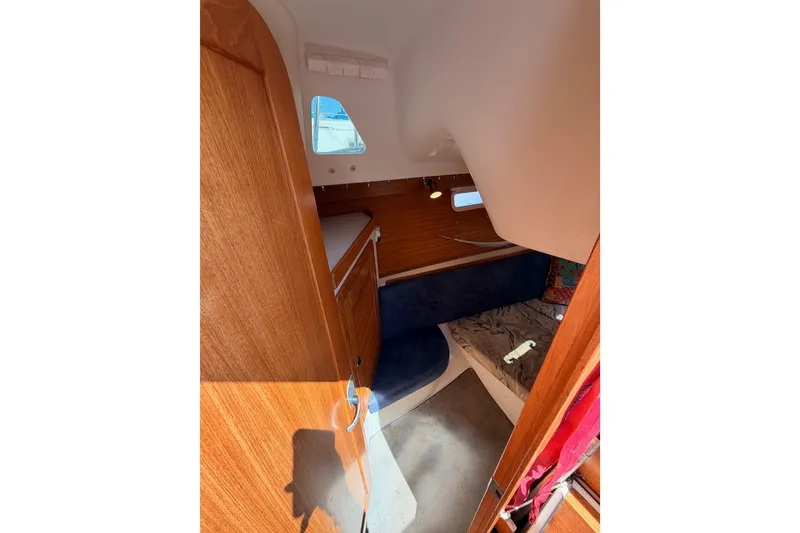 Slide: The Image of Interior cabin of a 1999 Catalina 320 sailboat with wooden finishes and seating area. - 32
