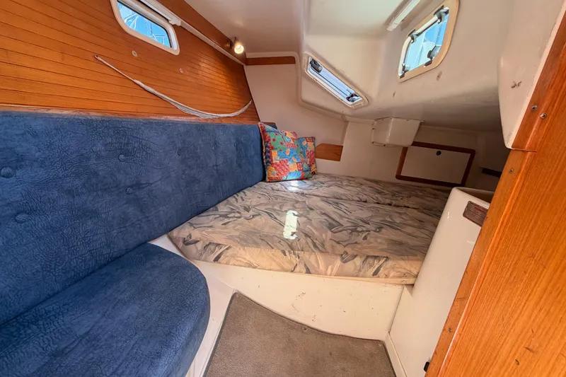 Slide: The Image of Interior cabin of a 1999 Catalina 320 sailboat with blue seating and patterned cushions. - 33