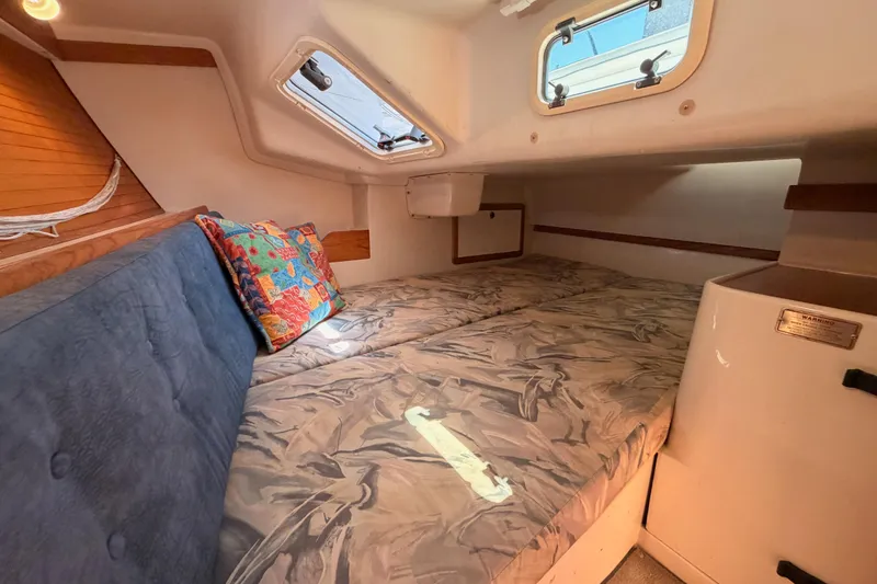 Slide: The Image of Cozy cabin interior of a 1999 Catalina 320 sailboat with bedding and colorful pillows. - 34